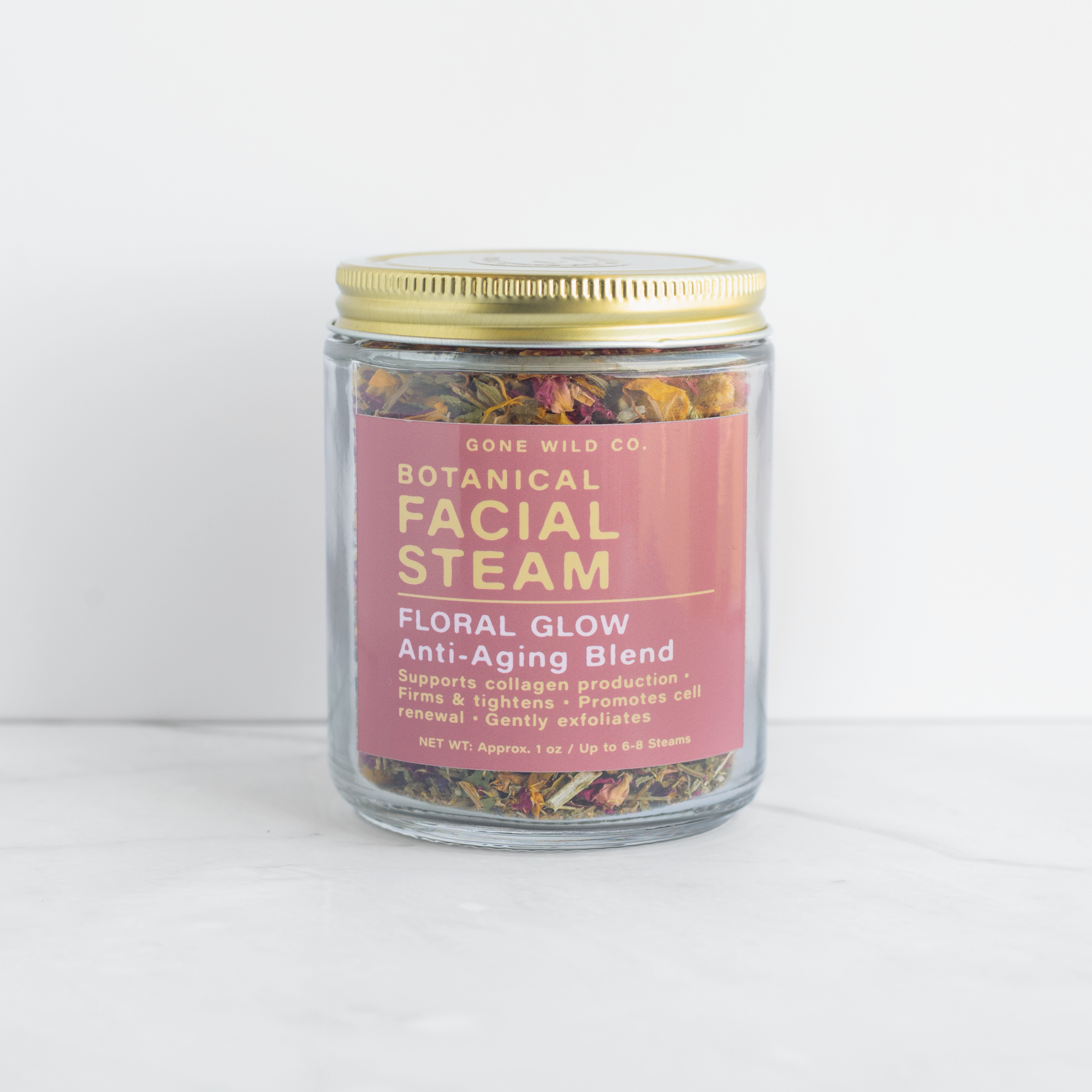 Glass jar of botanical facial steam with a gold lid on a white background